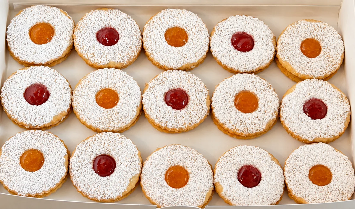 Our strawberry and apricot Linzer cookies arranged in a bakery box