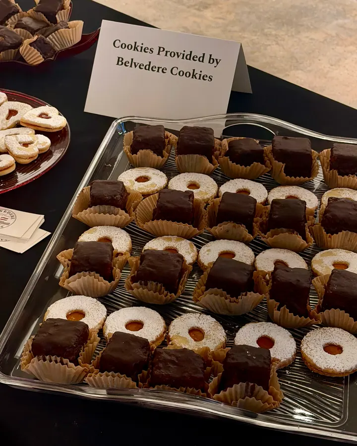 Linzer cookies and Sachertorte squares on a tray beside a card reading Cookies Provided by Belvedere Cookies