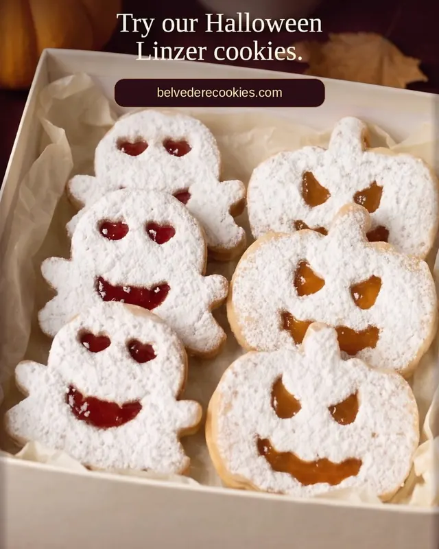 A box of sugar-dusted ghost and pumpkin Linzer cookies with jam windows, from our Halloween Reel